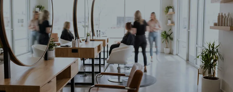 A hair salon with styling chairs and round mirrors