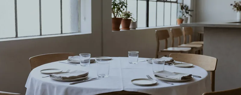A restaurant table set for service in an empty dining room