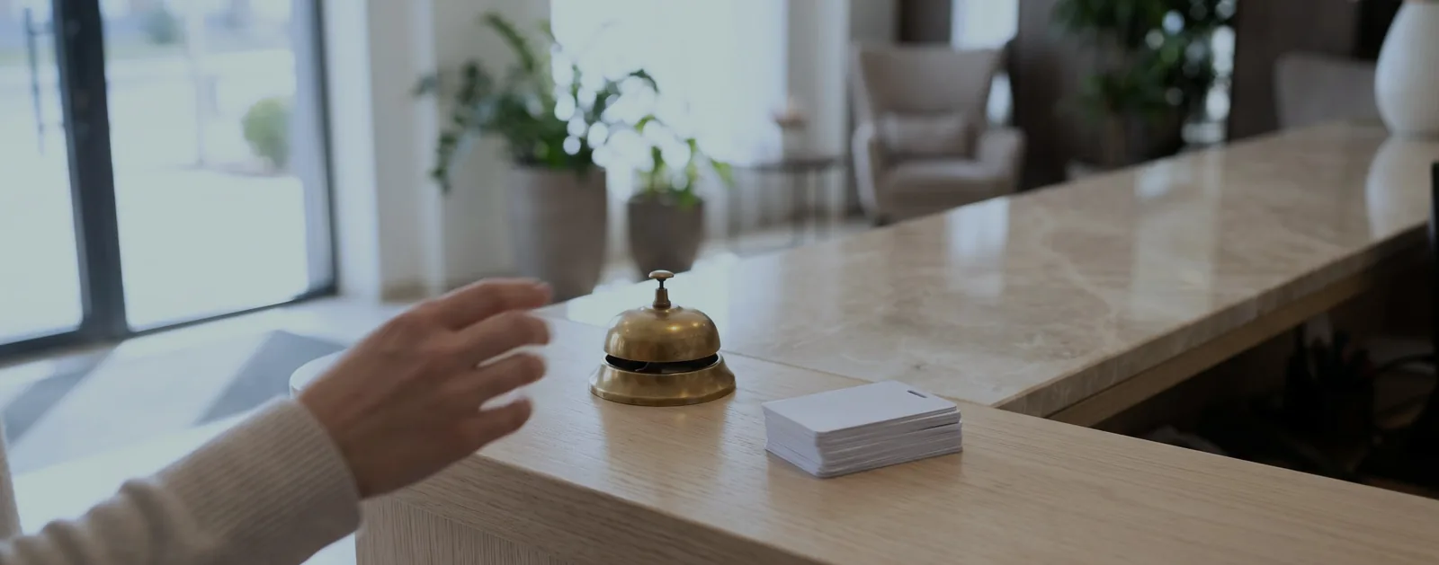 A boutique hotel front desk with a brass bell and key cards