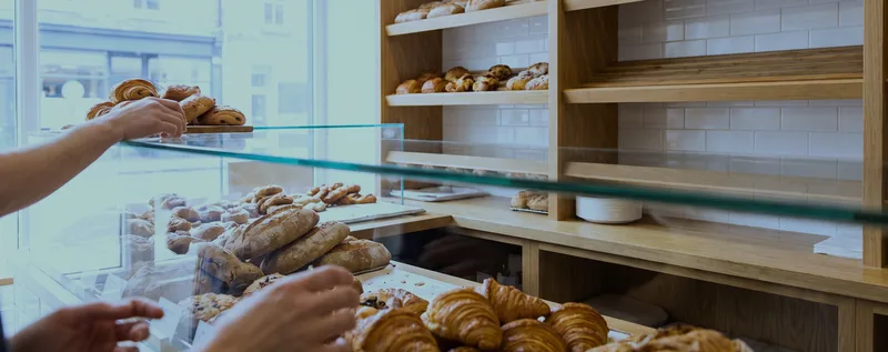 A bakery counter with a pastry case and shelved bread