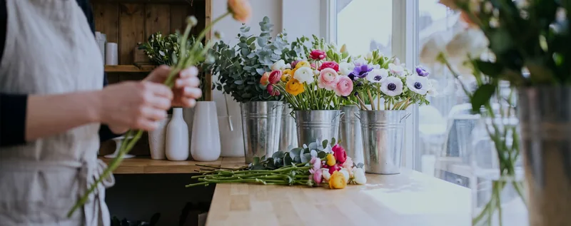 A flower shop counter with buckets of fresh flowers